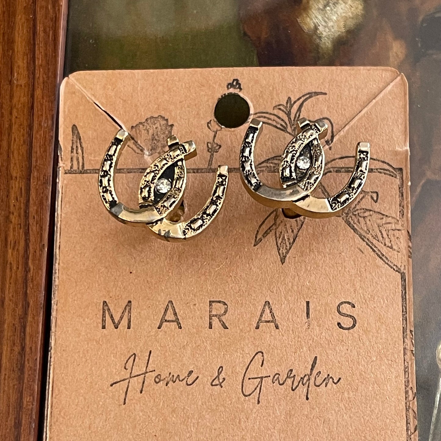Horseshoe-shaped cufflinks on a Marais Home & Garden card.