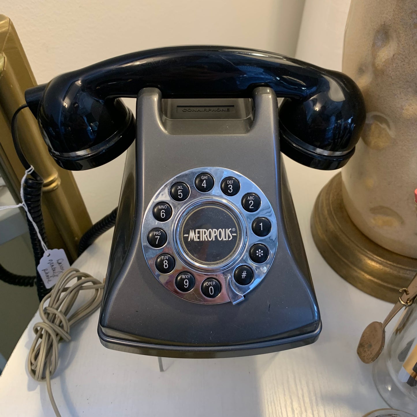 Vintage rotary phone with 'Metropolis' branding on a white surface.