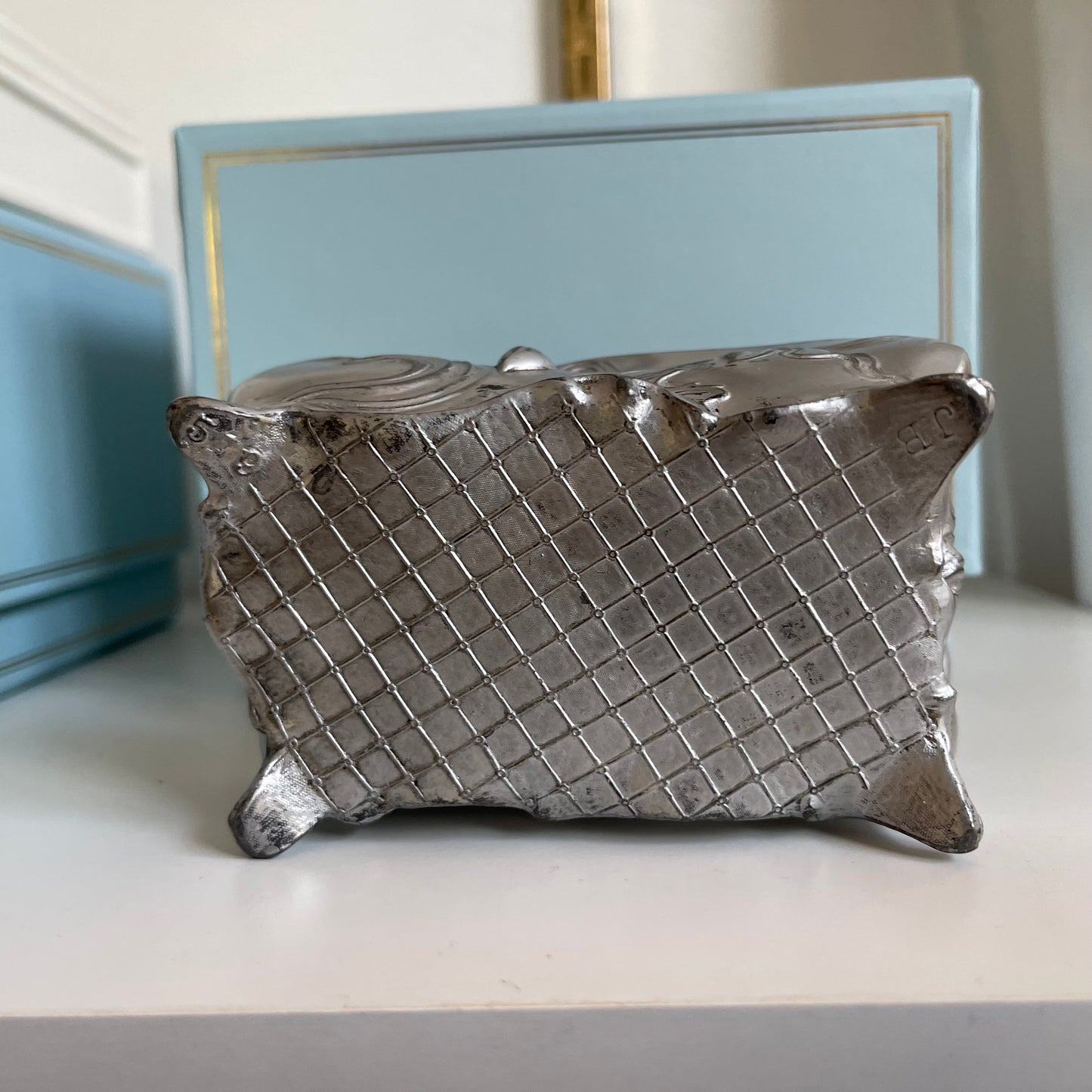 Decorative silver jewelry box bottom on a light surface with a blurred background