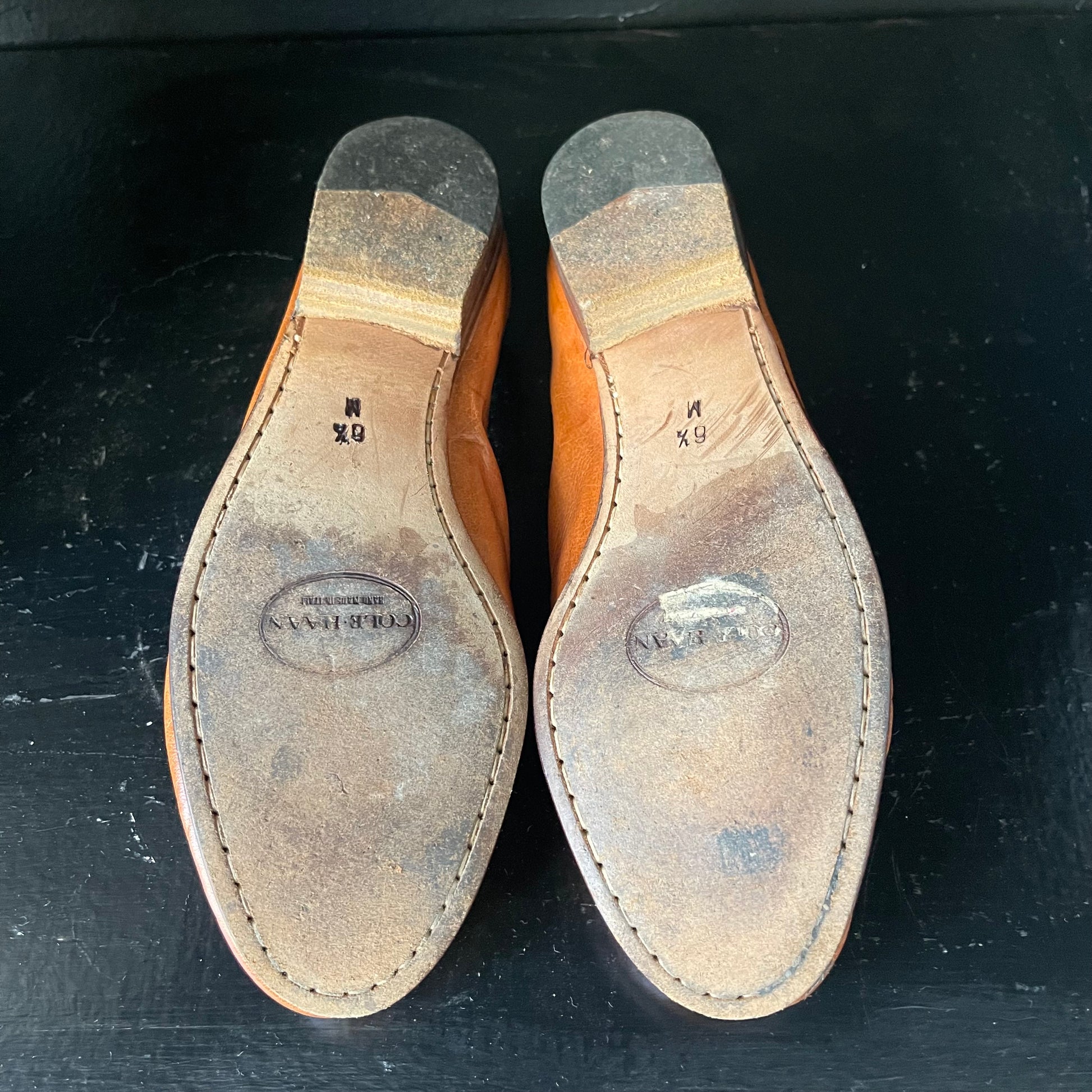 Brown leather Cole Haan shoe soles with visible wear and 6 and a half marking 