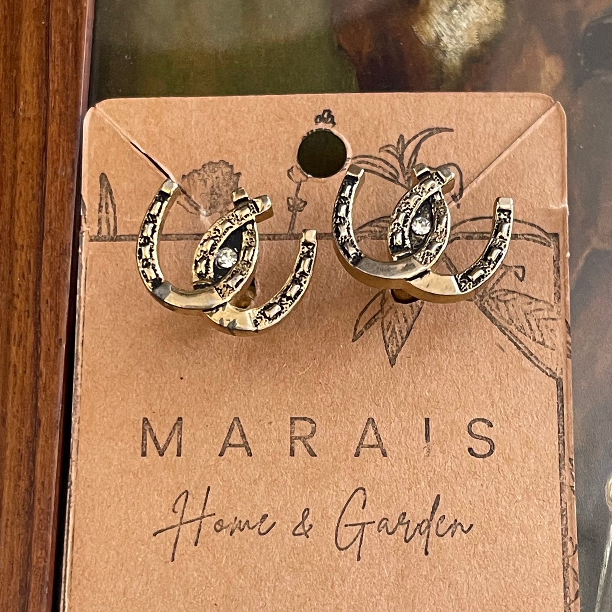 Horseshoe-shaped cufflinks on a Marais Home & Garden card.